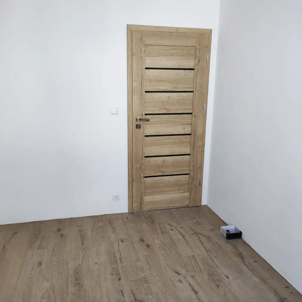 Drzwi wewnętrzne w dekorze drewna z czarnymi wstawkami szklanymi