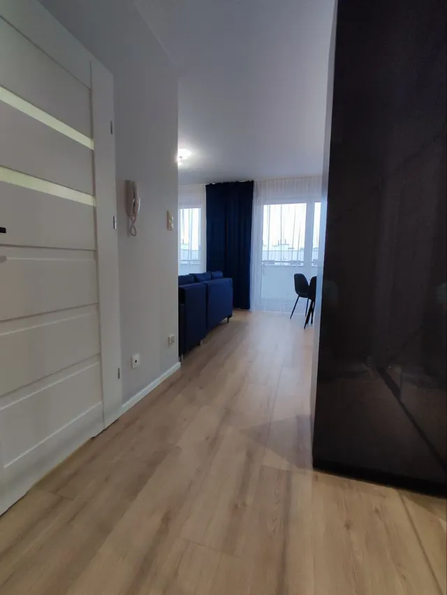 Przejście z przedpokoju do salonu z szafą z lustrzanymi frontami